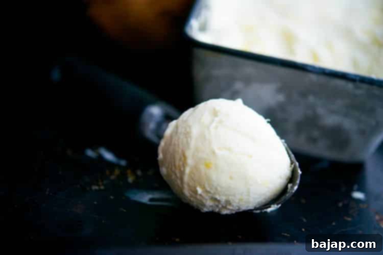 A bowl of creamy pineapple coconut ice cream, garnished with toasted coconut flakes.