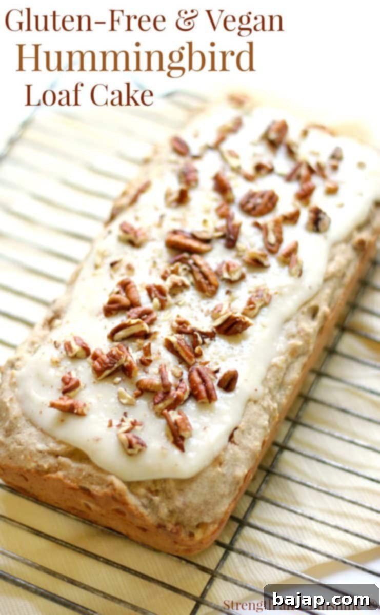 A slice of gluten-free vegan hummingbird loaf cake with frosting.