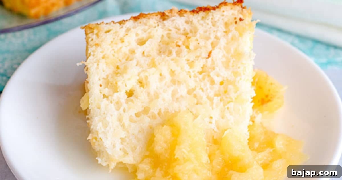 A fluffy pineapple angel food cake with a pineapple sauce drizzled over.