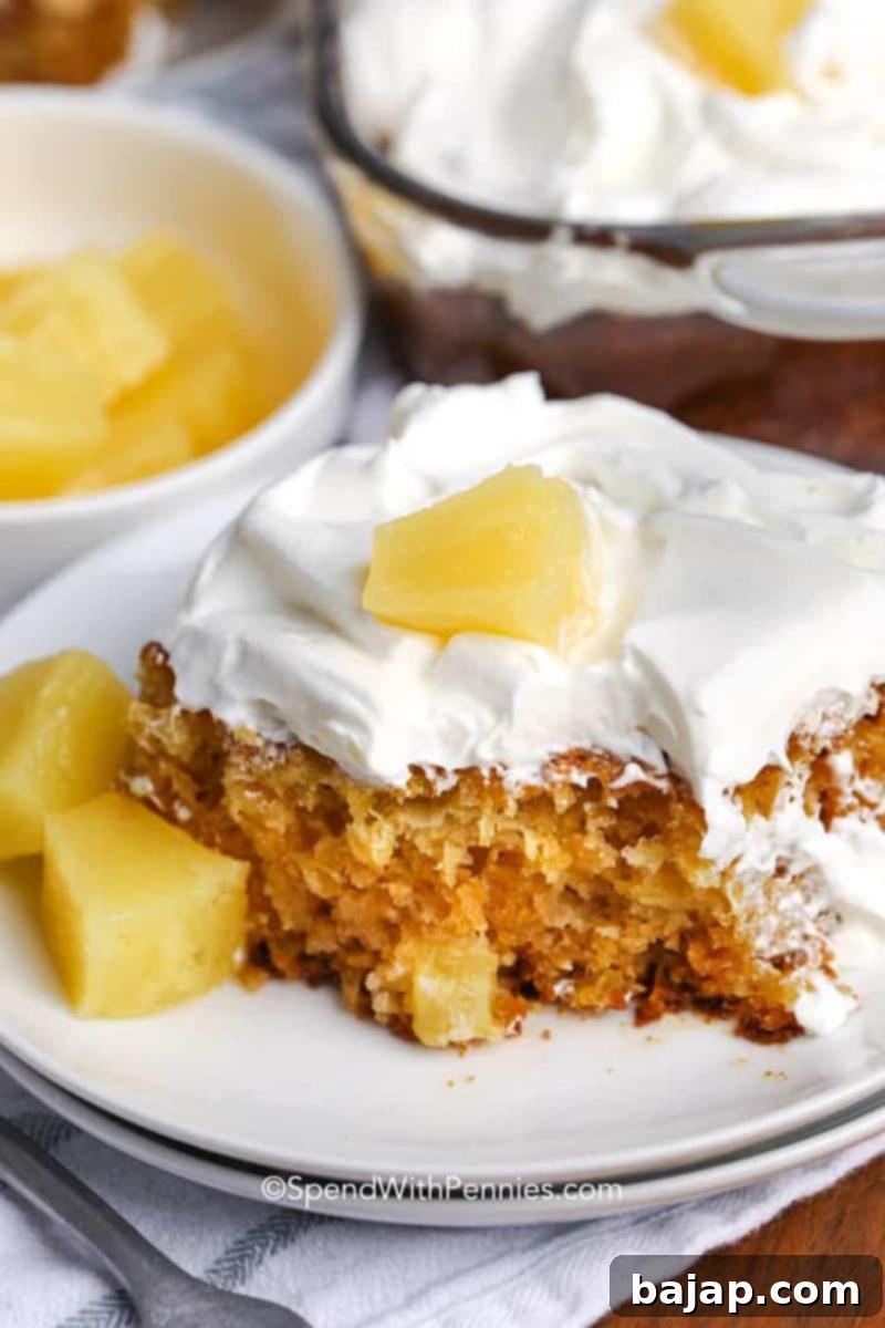 A slice of the easiest ever pineapple cake on a white plate.