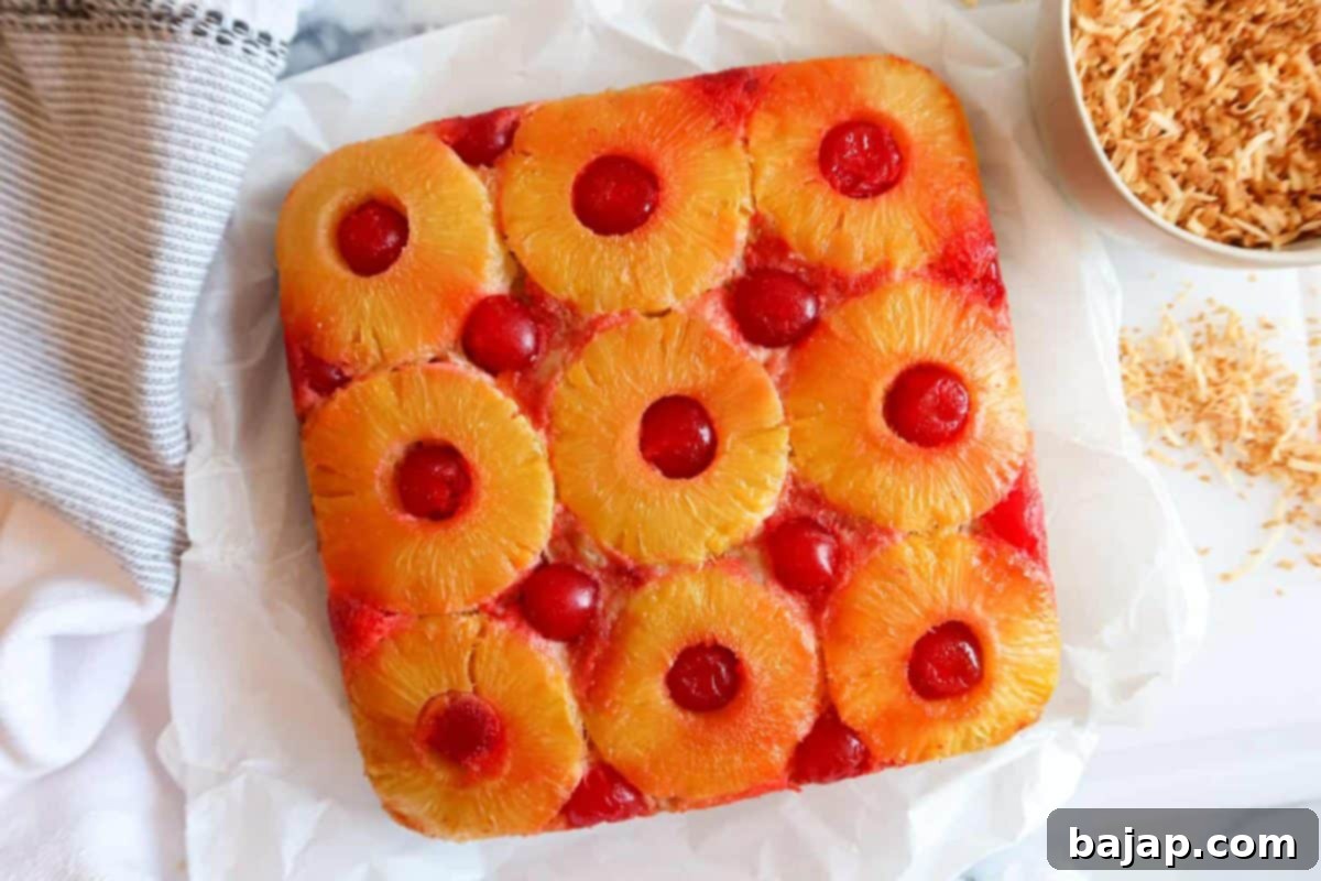 A square dish of pineapple upside down baked oatmeal, topped with caramelized pineapple slices.