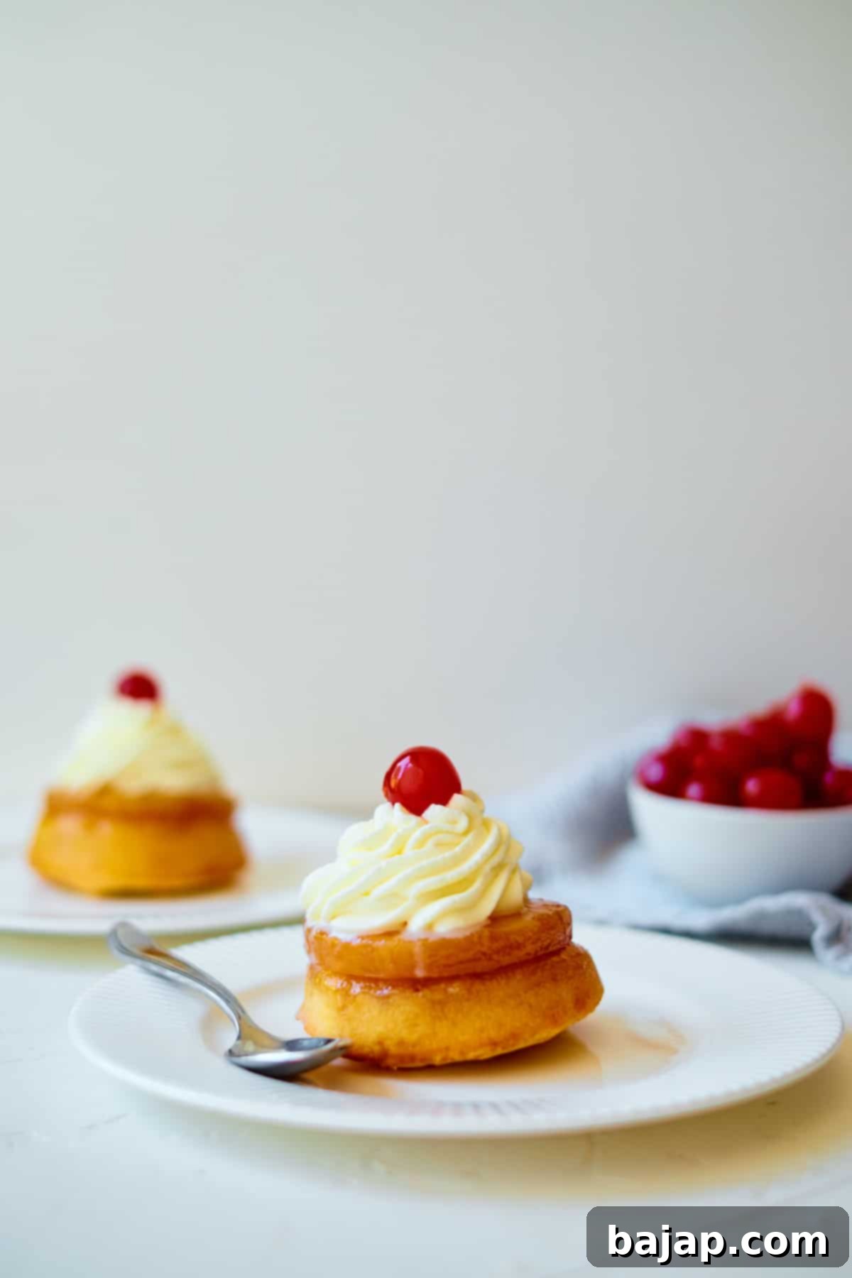 Pineapple Upside Down Cupcakes, individually baked and topped with pineapple and cherries.