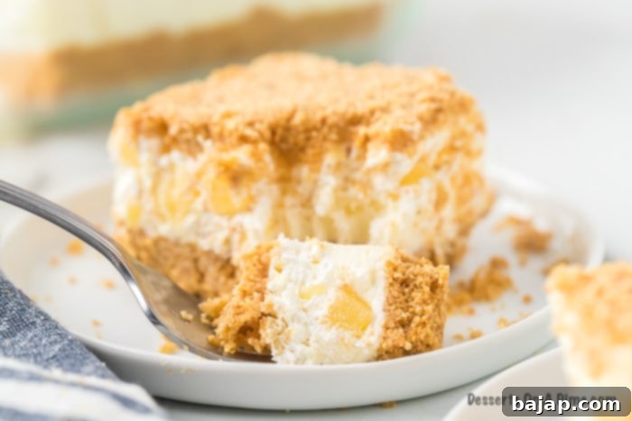 A layered pineapple dream dessert in a glass dish.