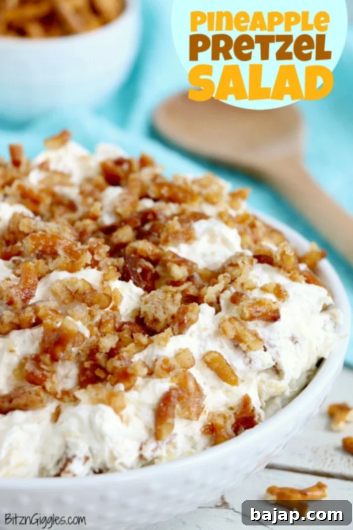 Pineapple Pretzel Salad in a glass bowl, showcasing layers of creamy fluff and pretzel crust.
