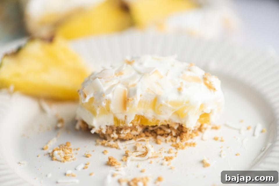 A square pan of No-Bake Tropical Coconut Pineapple Lush Cake, ready to be served.