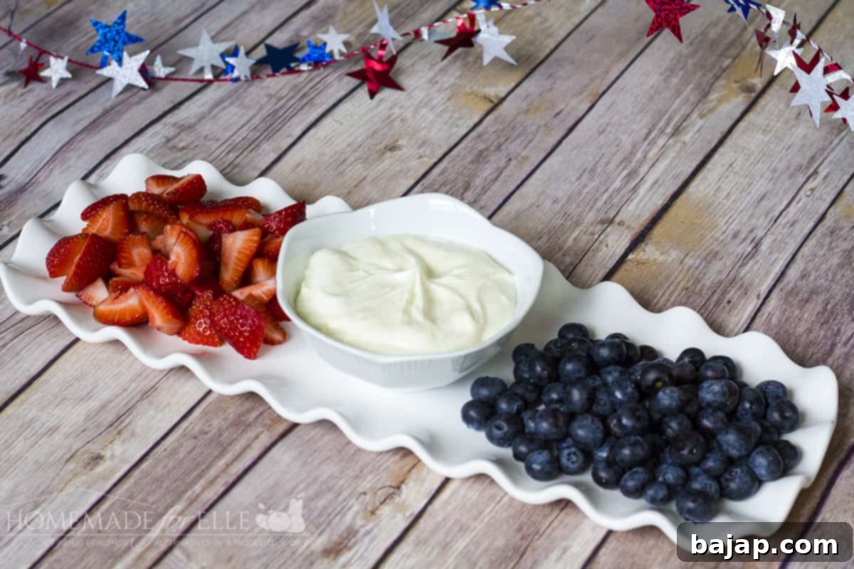A bowl of creamy pineapple fruit dip surrounded by fresh fruit slices.
