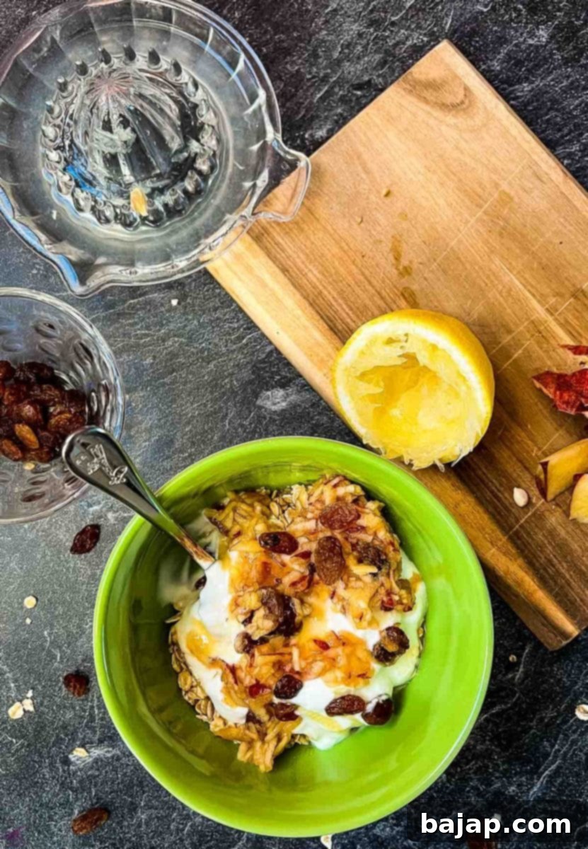 Breakfast bowl with grated apples, raisins, yogurt, honey and rolled oats. 