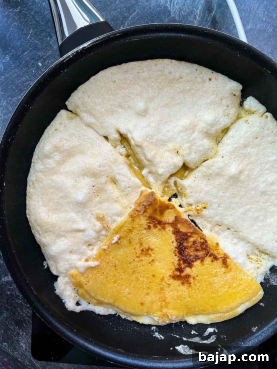 Flipping a quarter of the pancake in the pan to cook the other side until golden brown.
