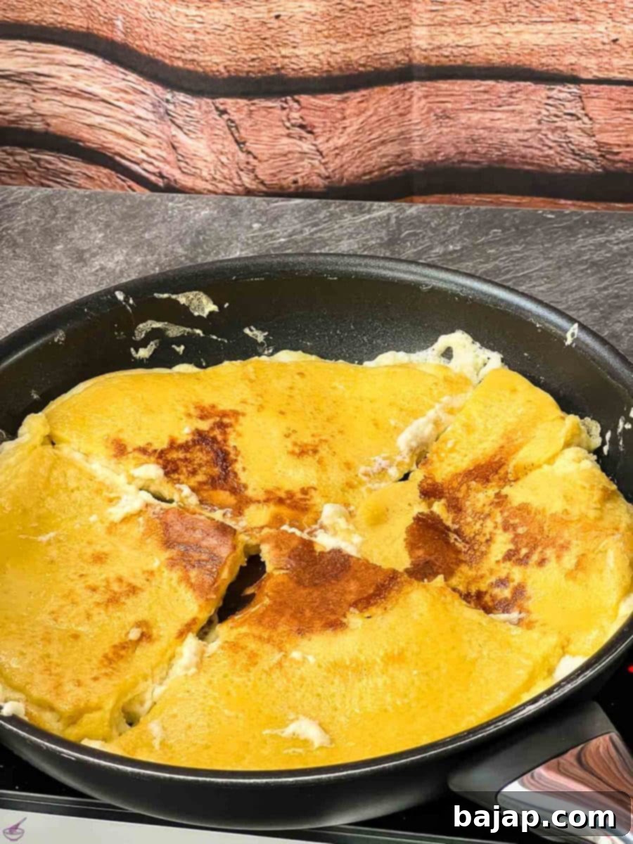 The other side of the pancake quarters frying in the pan, achieving a rich golden-brown hue.