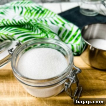 A preserving jar filled with granulated sugar and a vanilla bean, creating aromatic homemade vanilla sugar.