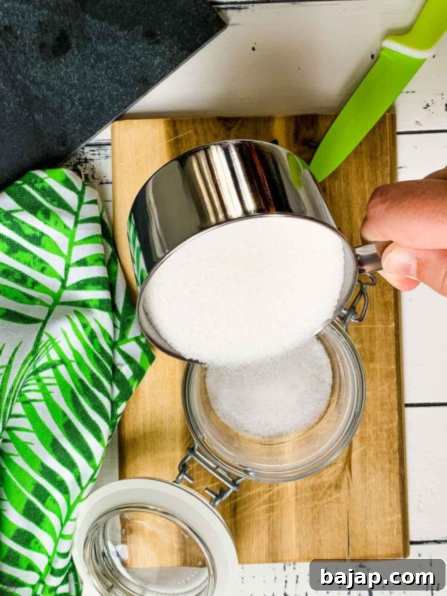 Pouring in a cup of granulated sugar into a preserving jar. 