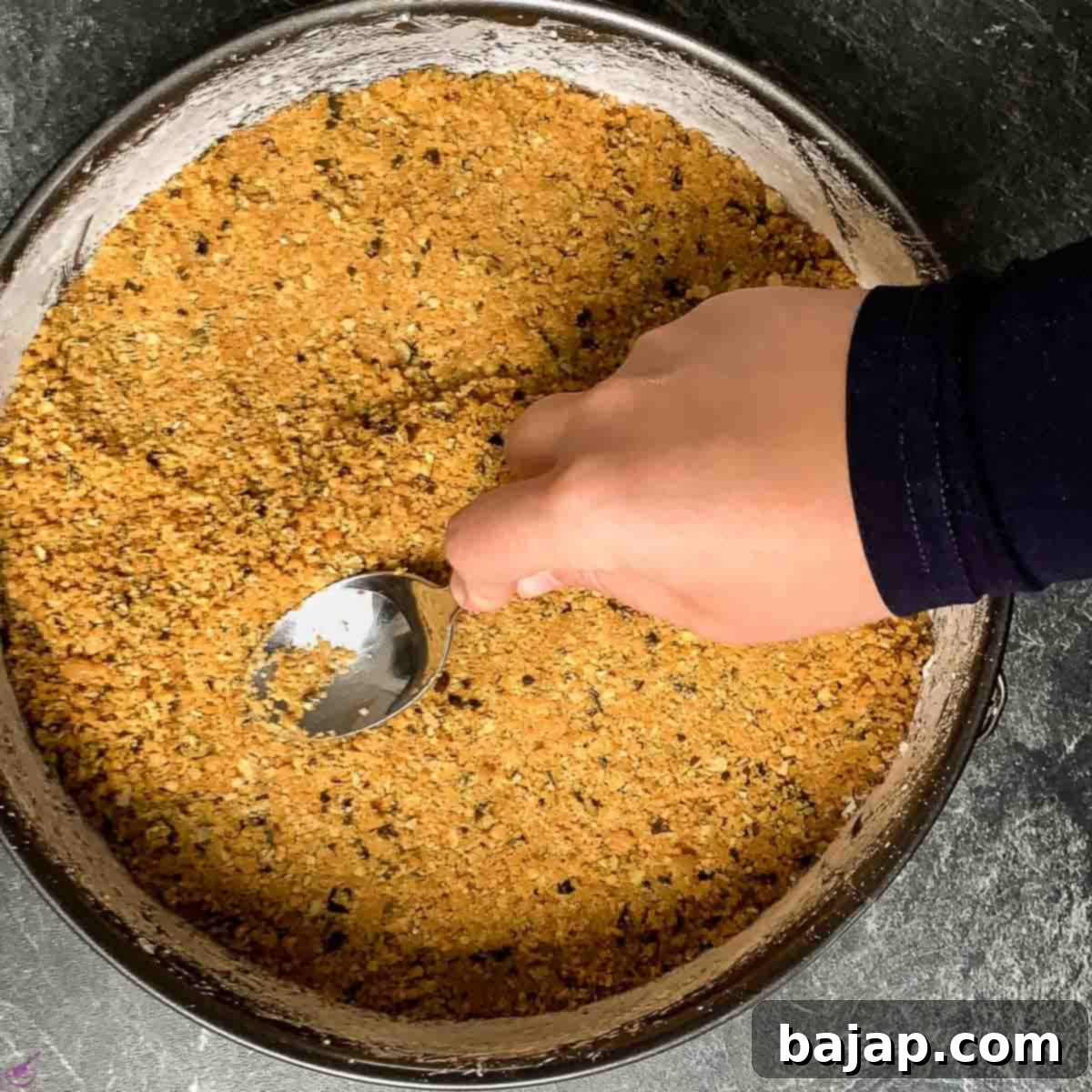 Create the crust by pressing the crumbs inside the pan.