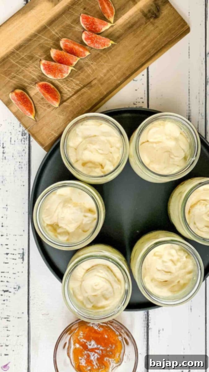 Filled preserving jars with cookie crumb base and cream cheese mixture. Fig preserves and fresh figs next to them.