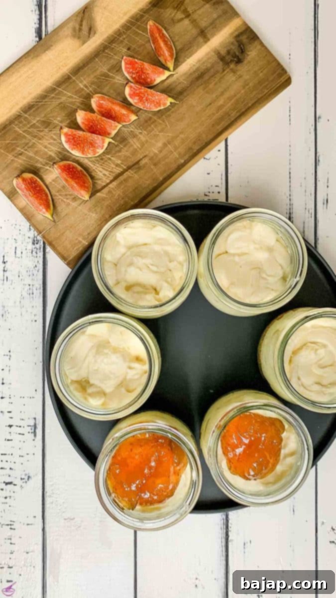 Filled preserving jars with cookie crumb base and cream cheese mixture. Fig preserves and fresh figs next to them.
