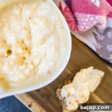 White bowl with egg salad spread and coated bread on brown board.