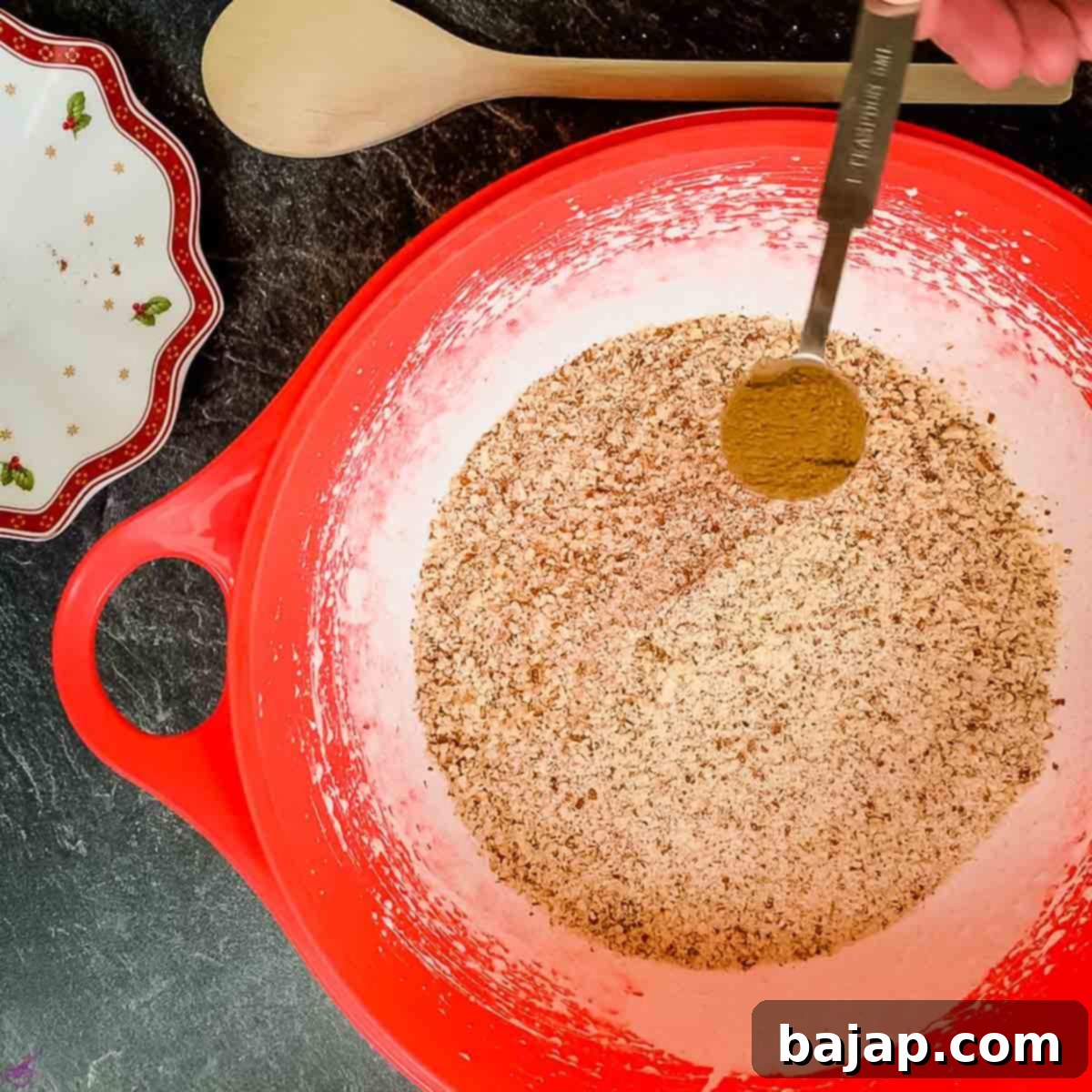Adding ground cinnamon to the egg white and almond mixture.