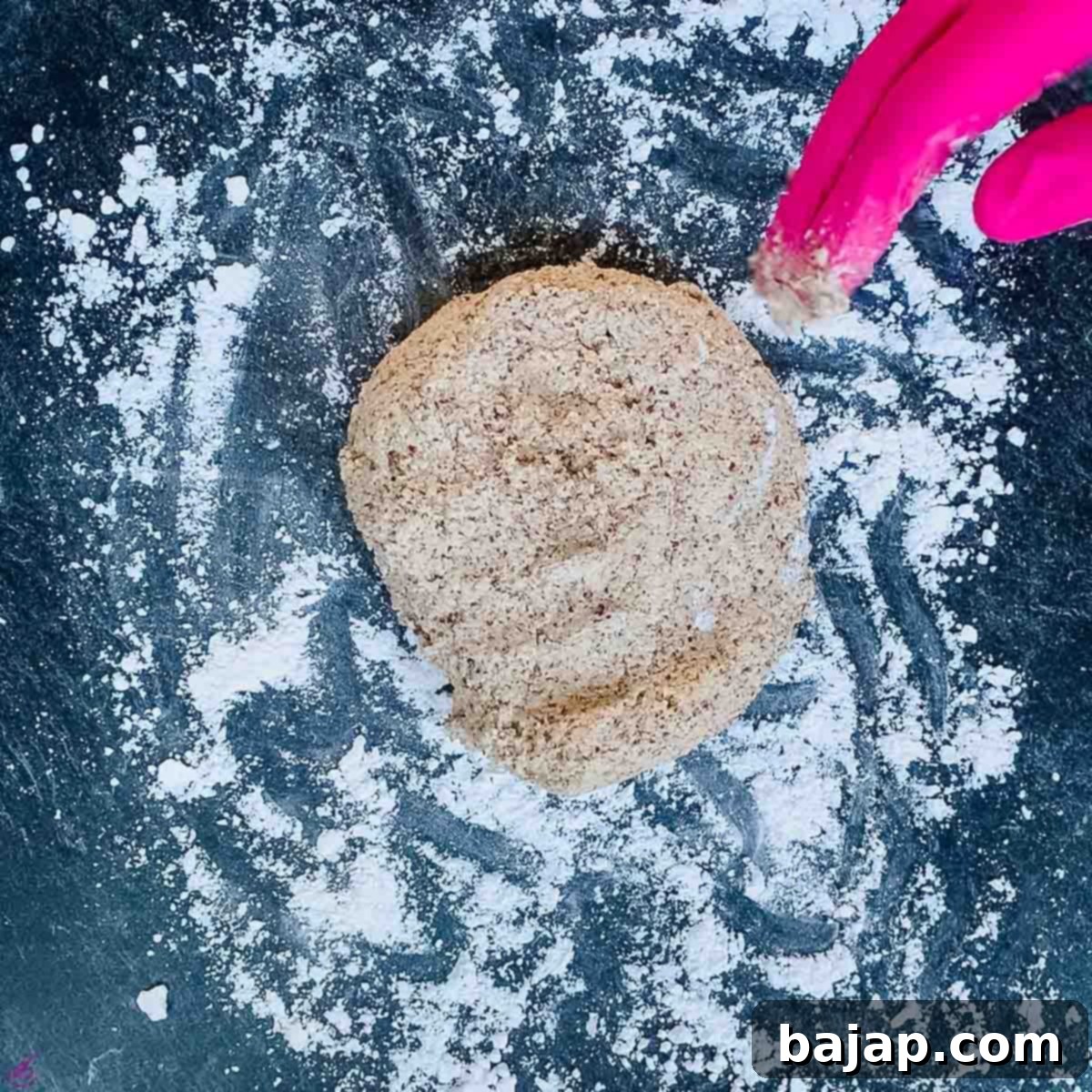Placing the sticky cinnamon cookie dough onto a work surface generously dusted with icing sugar.