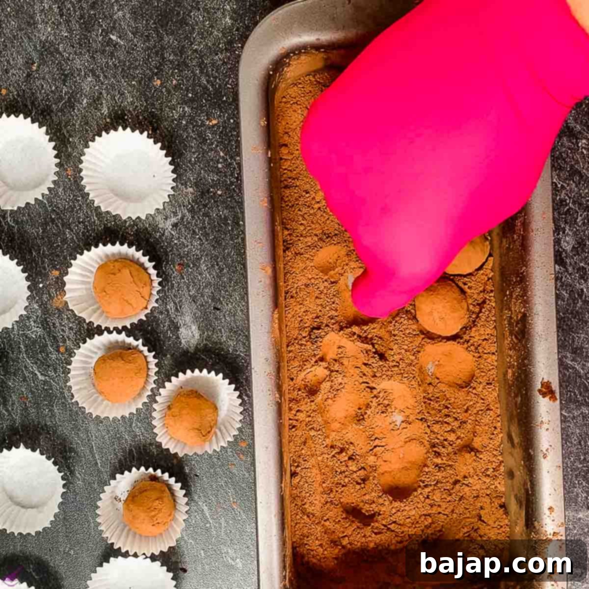 Rolling the Biscoff truffles in cacao powder and placing them into chocolate paper cups.