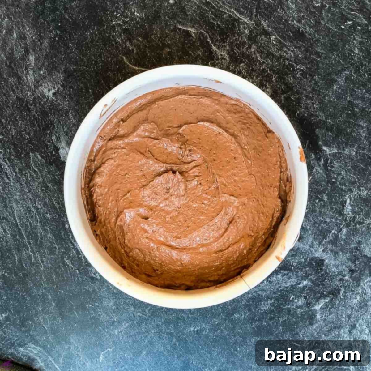 Springform pan filled with chocolate cake batter.
