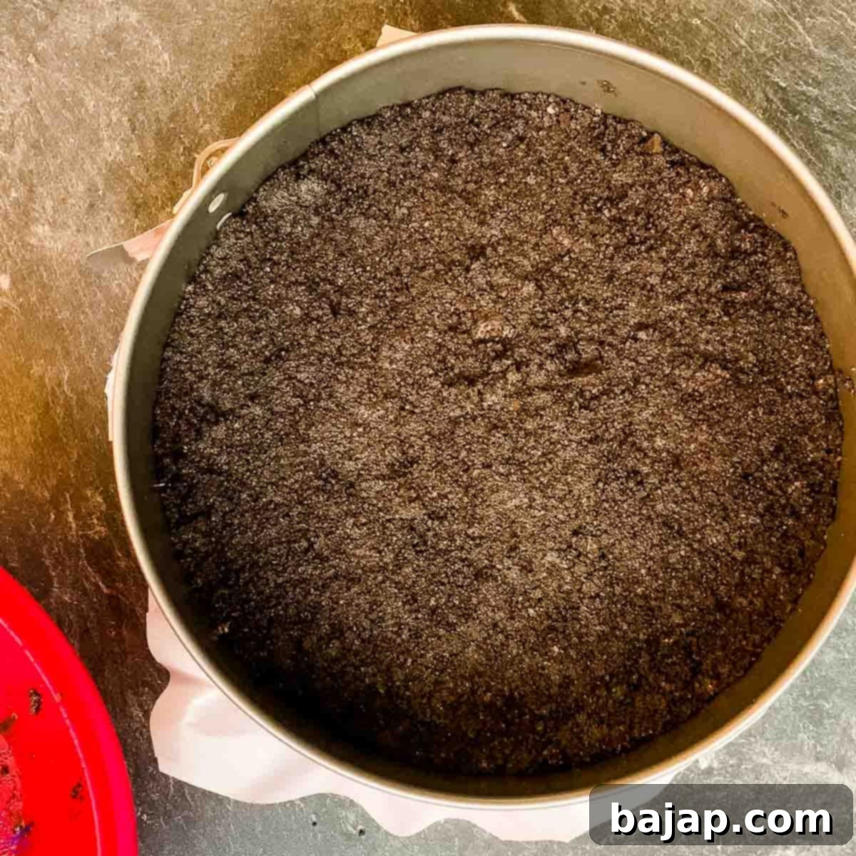 A finished Oreo cookie base in a springform pan, ready for the filling.