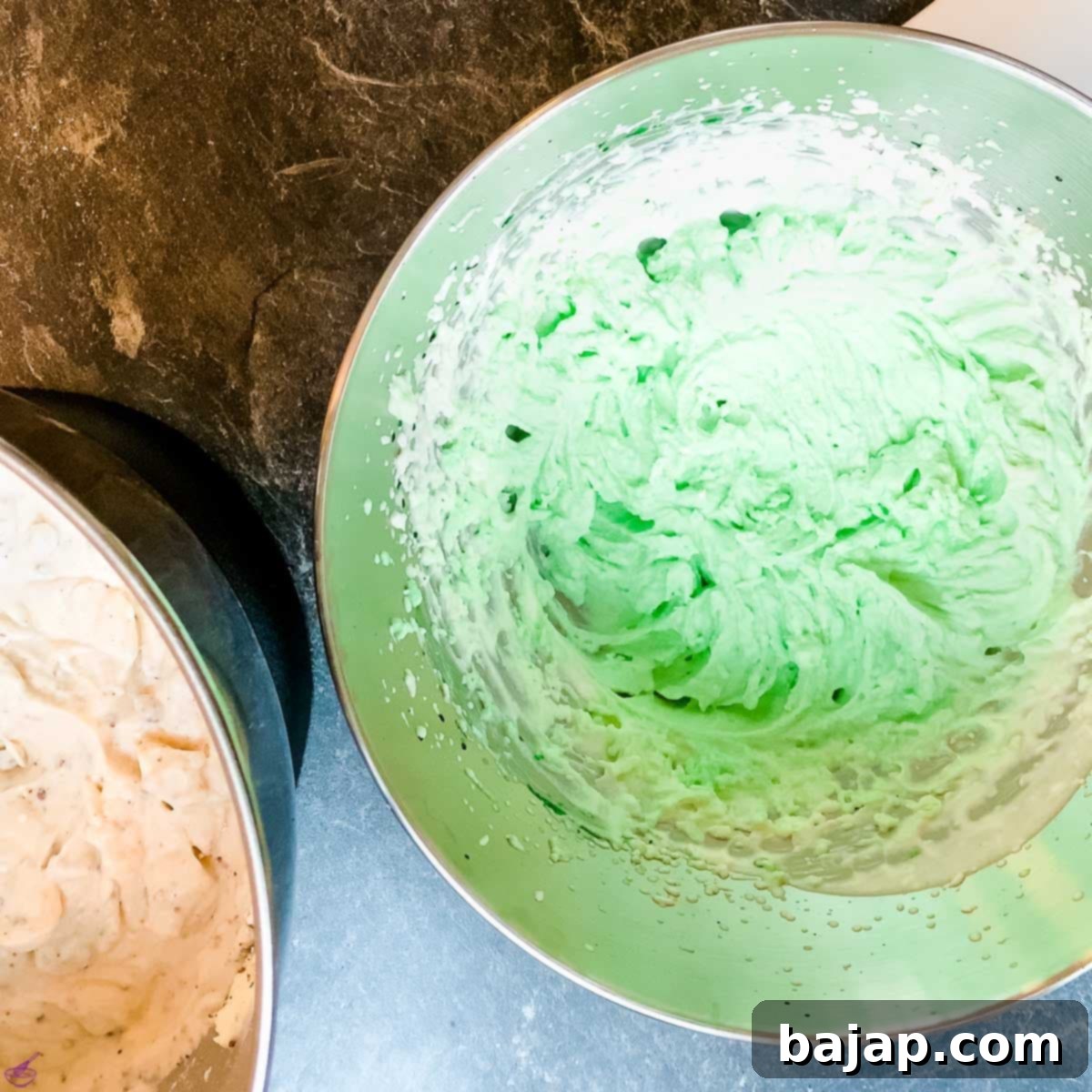 Adding green food coloring to whipped cream for the cheesecake filling.