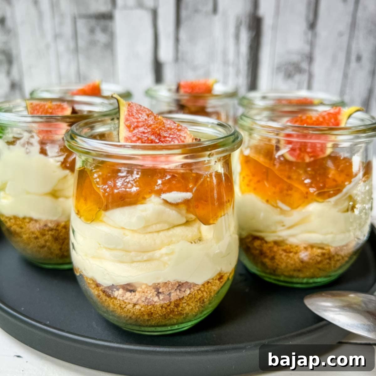 Ready prepared layer dessert. Fig cheesecake without baking with cream cheese filling, cookie base and fig preserve on top.