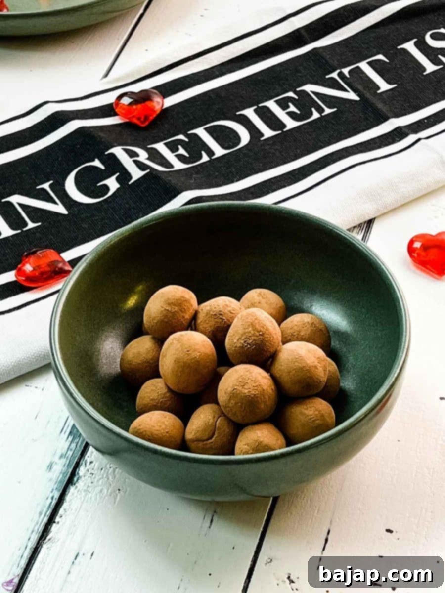 Delicious marzipan potatoes arranged in a dark green bowl, waiting to be packed or served.