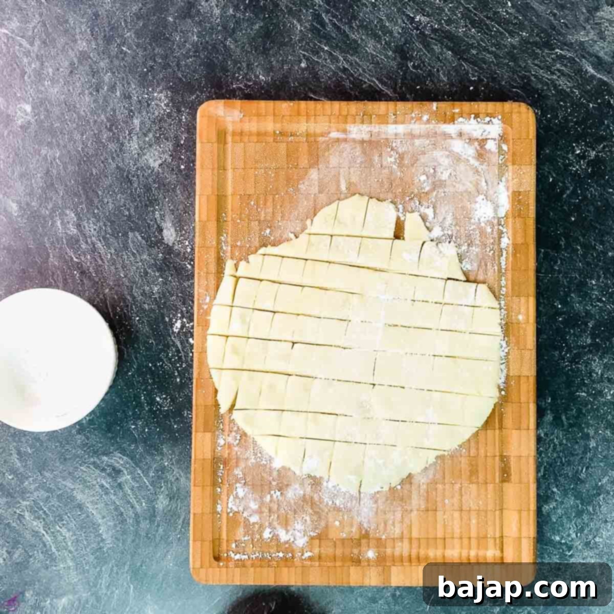 Marzipan paste neatly cut into small, uniform cubes on a cutting board.