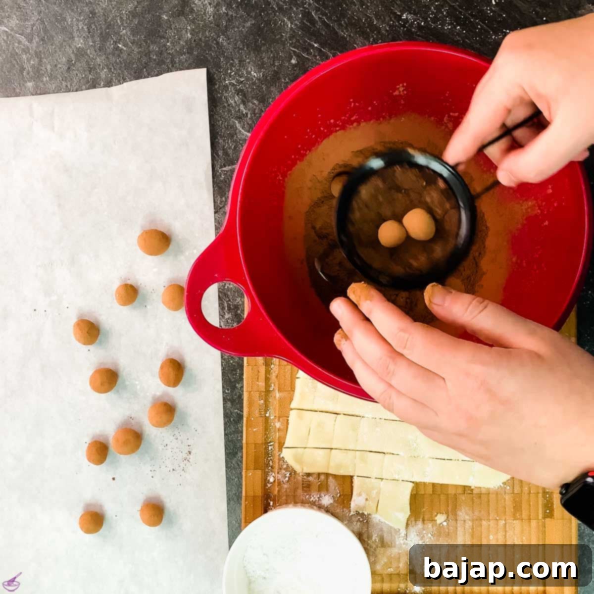 Roll the cocoa covered marzipan potatoes in a sieve to remove the excess cocoa.