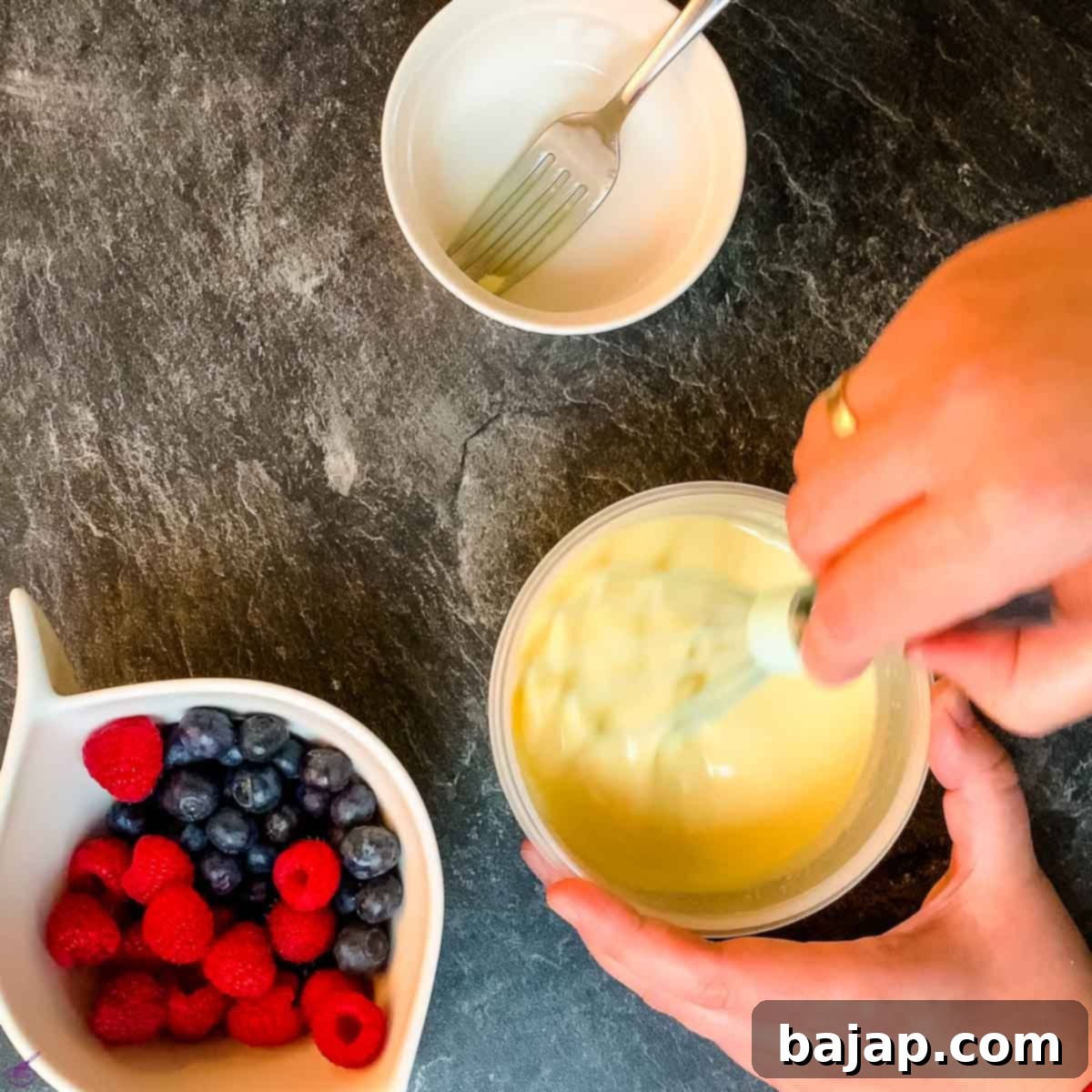 Combining white chocolate, whipped cream, and hydrated gelatin to create the smooth, glossy glaze for the cheesecake.