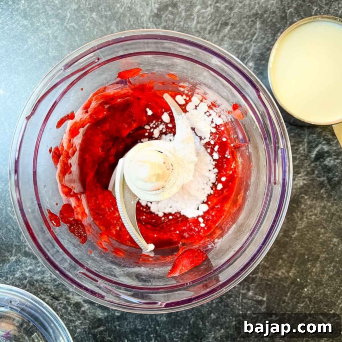 Combine the fresh strawberries with powdered sugar in a food processor to create a smooth, sweet purée.