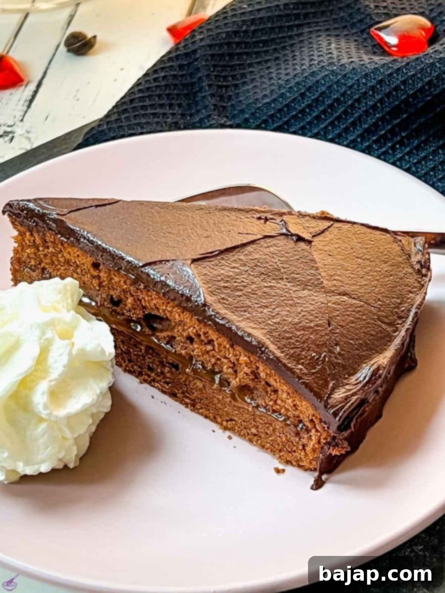 Serve a delicious slice of Sacher cake with a dollop of whipped cream, showcasing its dark shiny icing and moist apricot-infused dough.