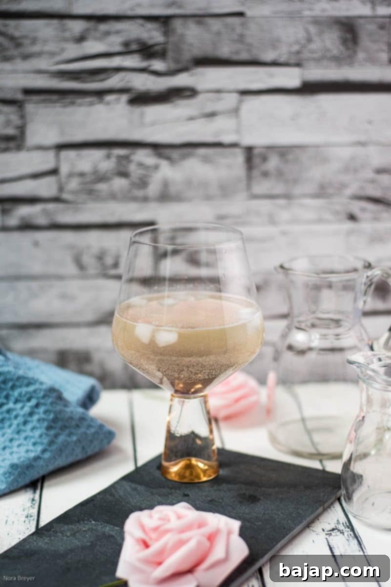 Refreshing lavender spritz with gorgeous color, garnished with a lemon slice and a sprig of lavender.