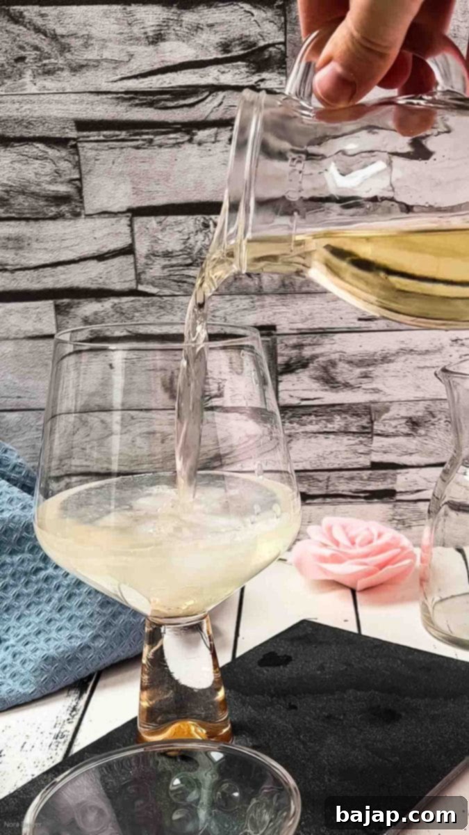 Pouring white wine into the glass with lemon juice and ice.