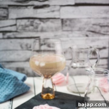 Refreshing lavender spritz with gorgeous color, garnished with a lemon slice and lavender sprig.