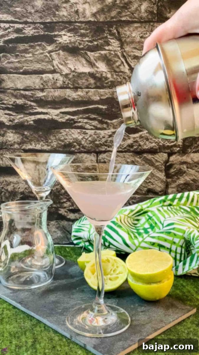 Gorgeous purple lavender daiquiri cocktail with a fresh lime slice on the rim, showcasing its vibrant color.