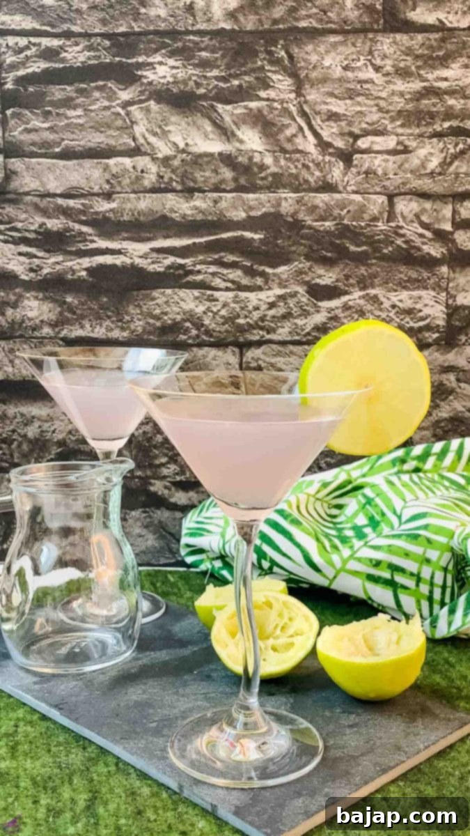 Close-up of a beautifully garnished lavender daiquiri in a coupe glass with a lime slice.