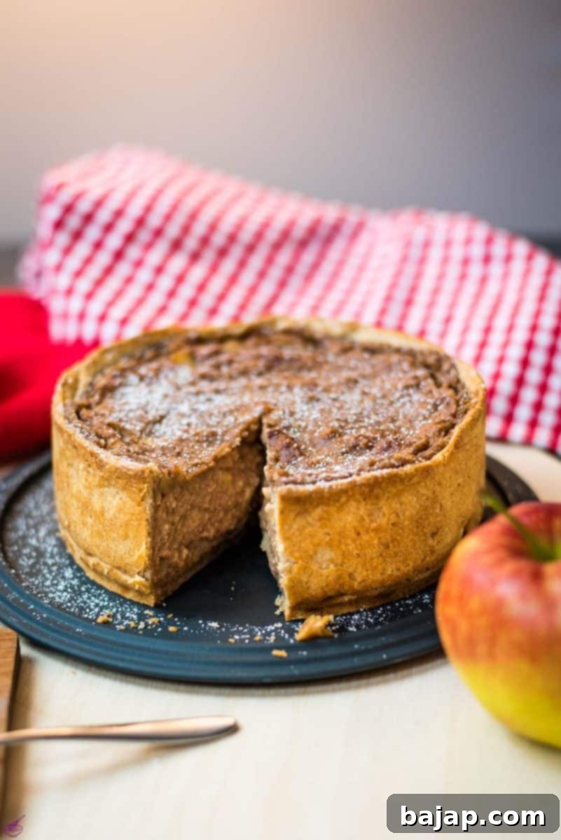 Delicious apple tart with a slice cut out. Dusted with powdered sugar.