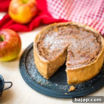 Delicious apple tart with a slice cut out. Dusted with powdered sugar.