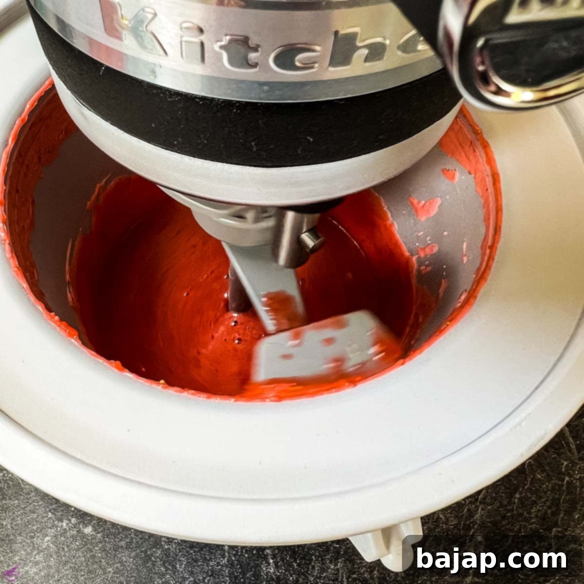 Ice cream maker filled with strawberry mixture, freezing the strawberry purée into ice cream.