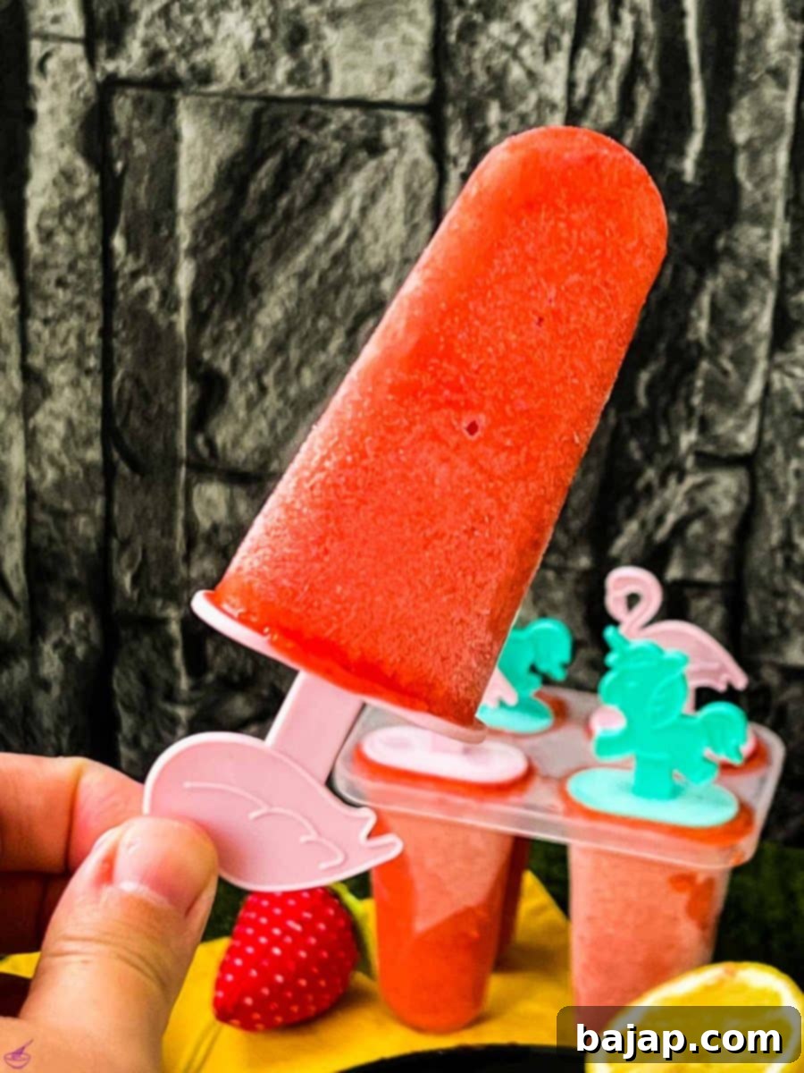 Close-up of a strawberry popsicle on flamingo popsicle stick.