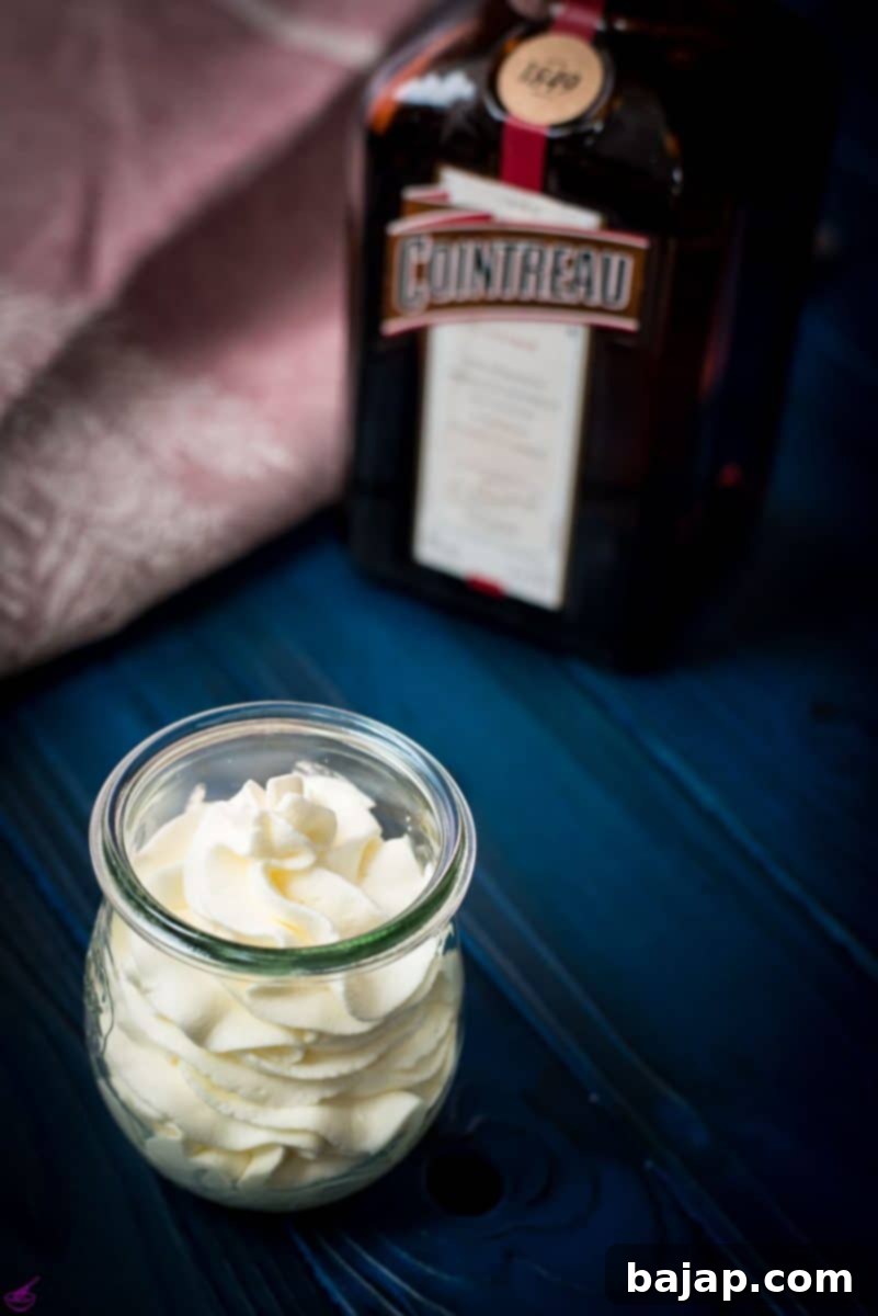 A tulip Weck jar filled with delicious orange flavored whipped cream on dark blue wooden floor.