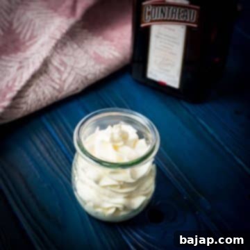 A tulip Weck jar filled with delicious orange flavored whipped cream on dark blue wooden floor.