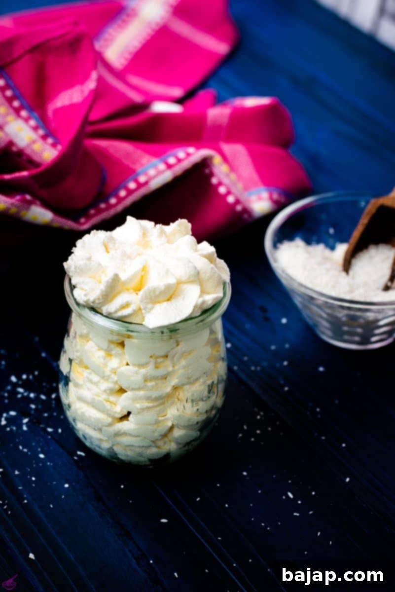 Coconut-flavored whipped cream in a Weck glass, on blue wooden ground.