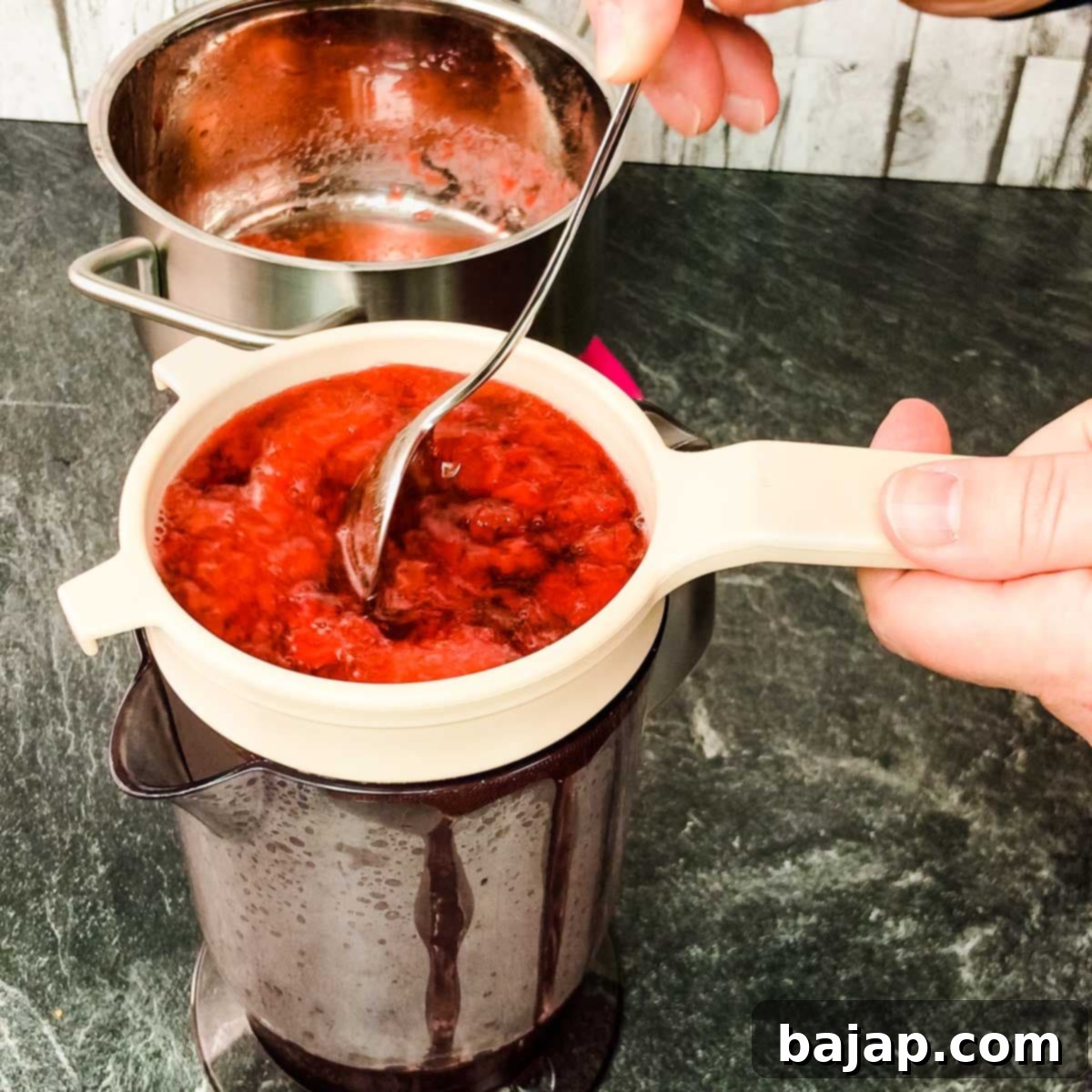 Strain the strawberry mixture through a fine mesh sieve to achieve a smooth, clear syrup.