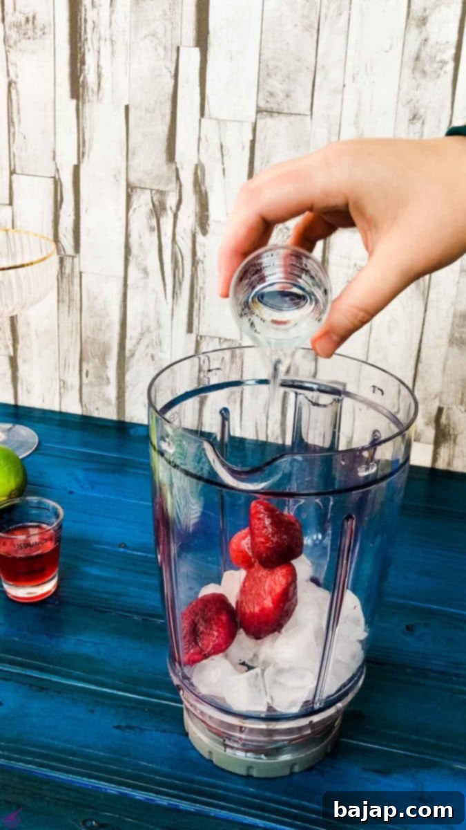 Add the white rum to the blenders' container to complete your strawberry daiquiri.