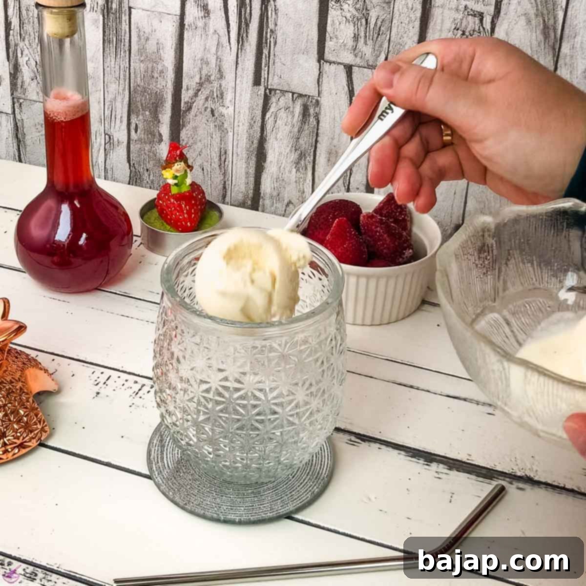 Quick & Creamy Homemade Strawberry Milkshake 4 Add two scoops of vanilla ice cream to the cocktail glass.