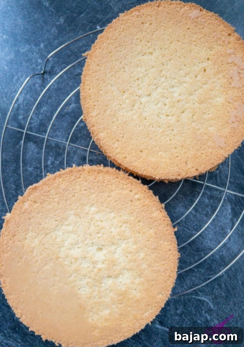 Two sponge cakes on cooling rack.