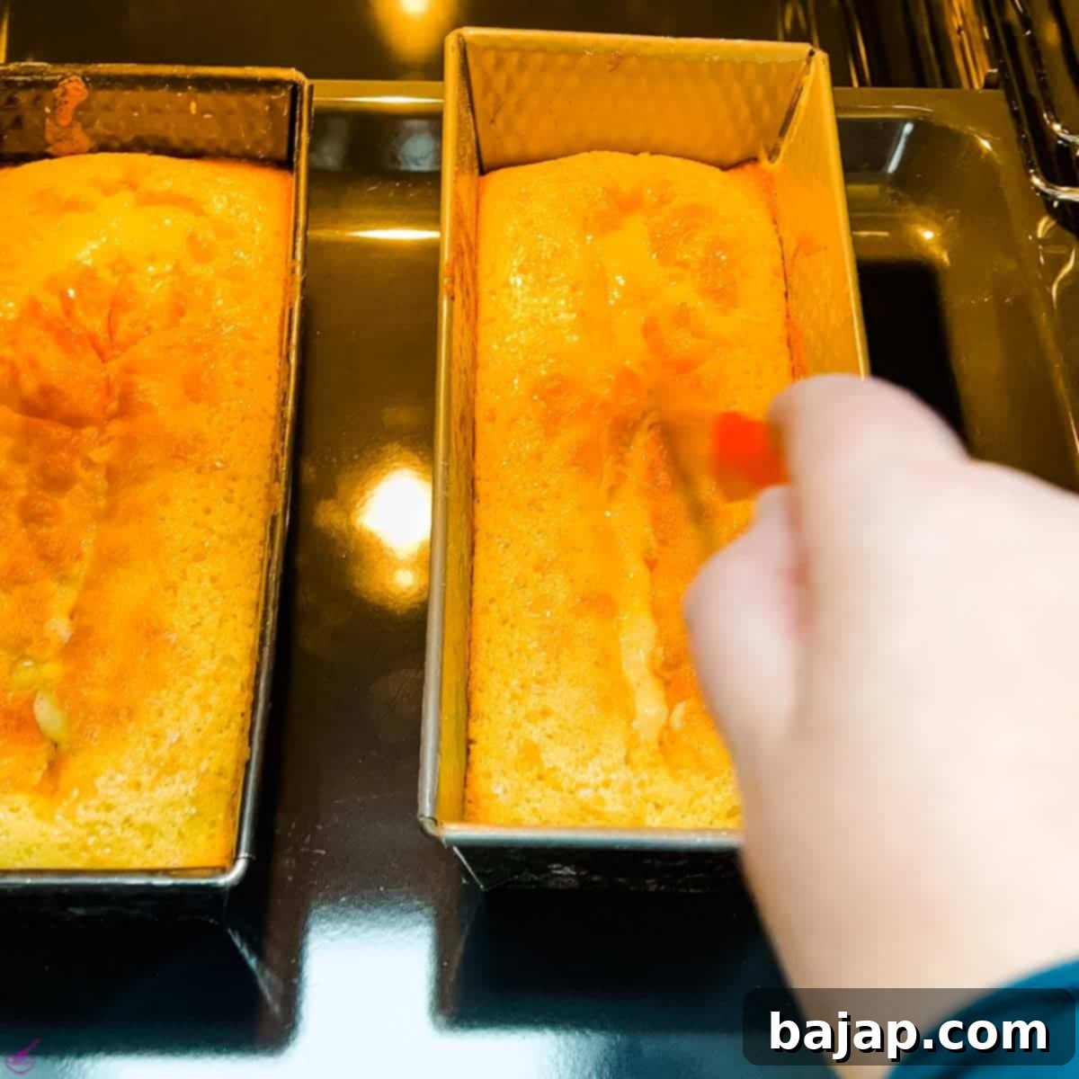 A close-up shot of the pound cake in its pan, showing a clean, lengthwise score made with a knife across its lightly baked surface, ready for the next stage of baking.