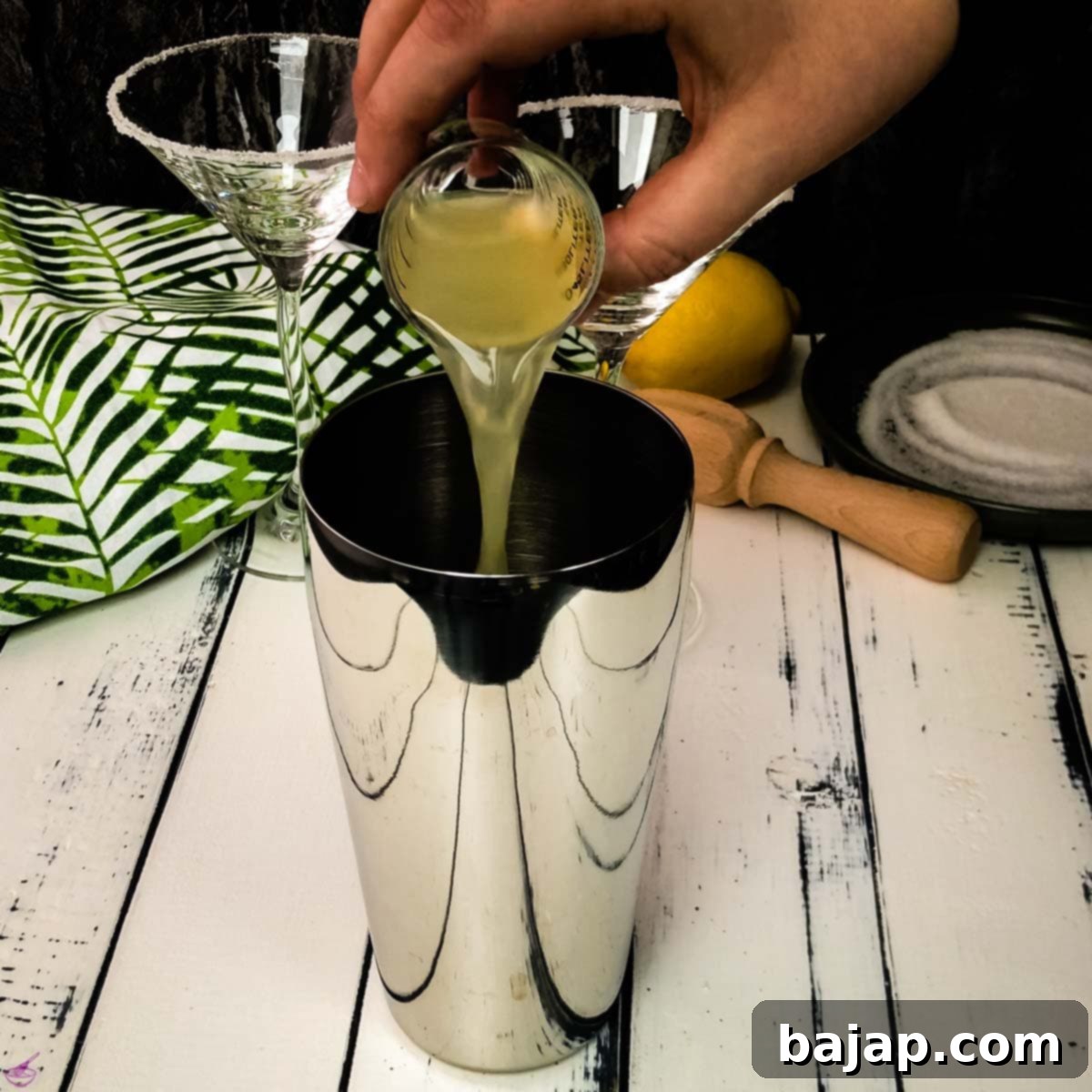 Pour the fresh lemon juice into the cocktail shaker for the Sidecar.